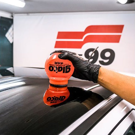 Hand mit Glaco Roll-on Max Scheibenbeschichtung auf Autoscheibe für ultra hydrophoben Effekt