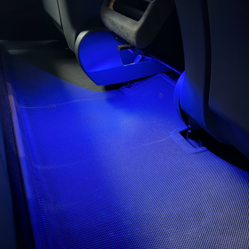Blaues LED-Licht leuchtet auf eine Matte hinter den Sitzen.