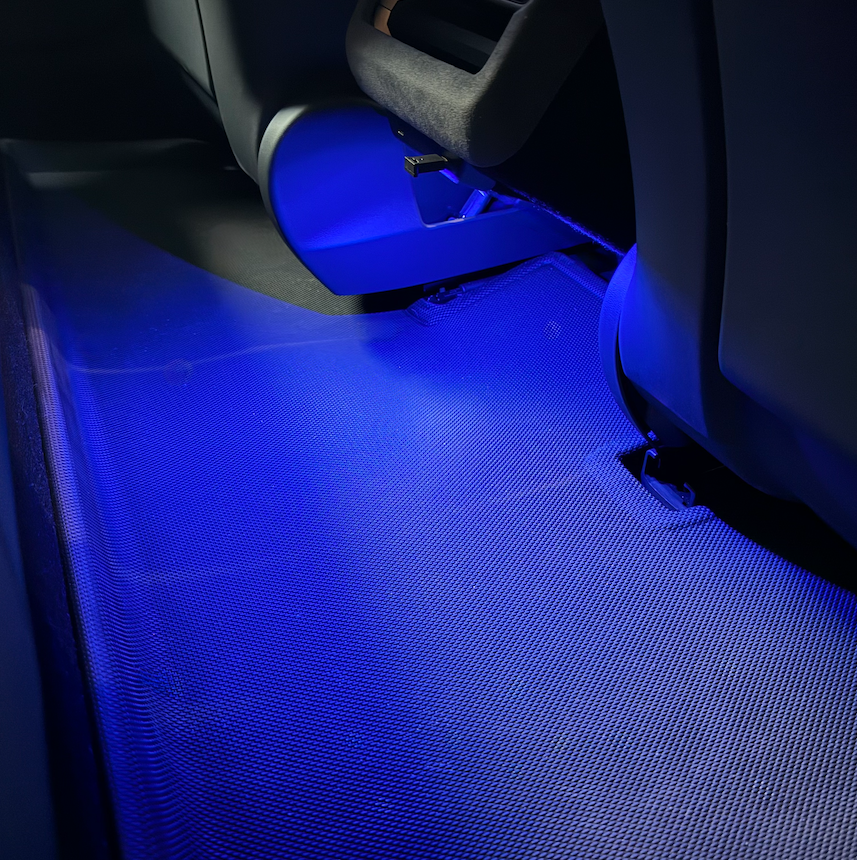 Blaues LED-Licht leuchtet auf eine Matte hinter den Sitzen.