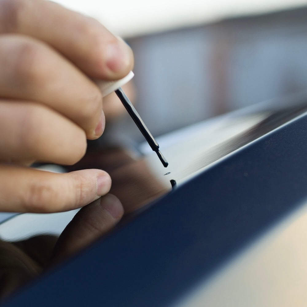 Lackstift, der verwendet wird, um einen Kratzer im Autolack zu erzeugen
