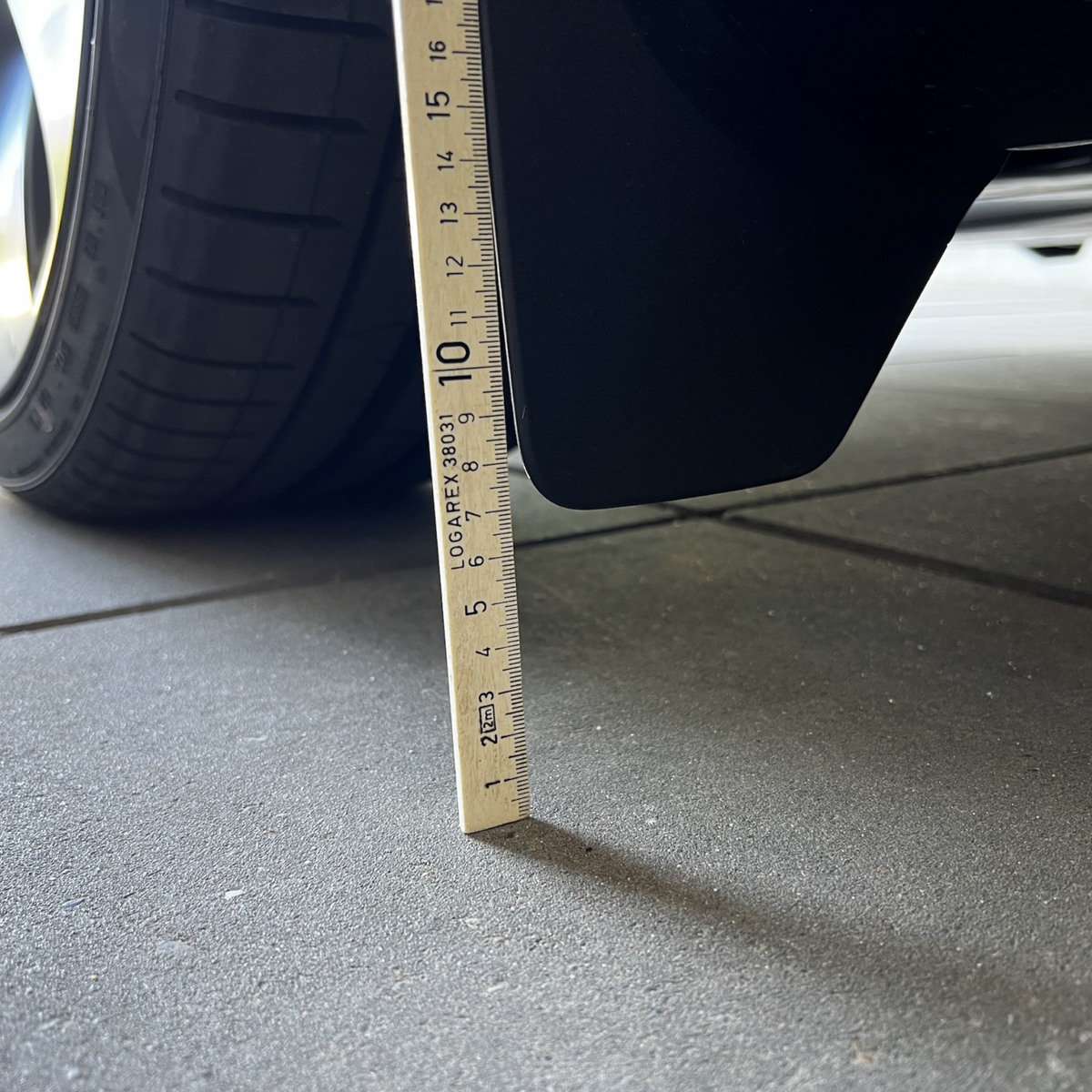 Originale Schmutzfänger am Tesla Model Y mit Lineal gemessen.