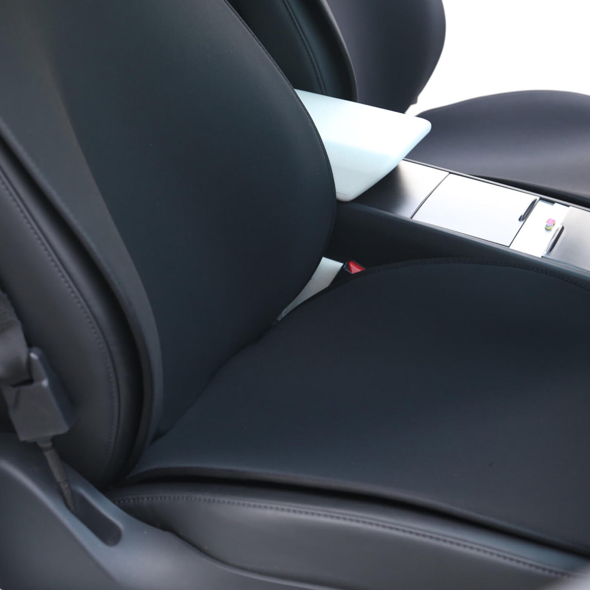 Schwarze Sitzbezüge montiert auf dem Vordersitz eines Tesla Model 3 oder Model Y, Nahaufnahme.