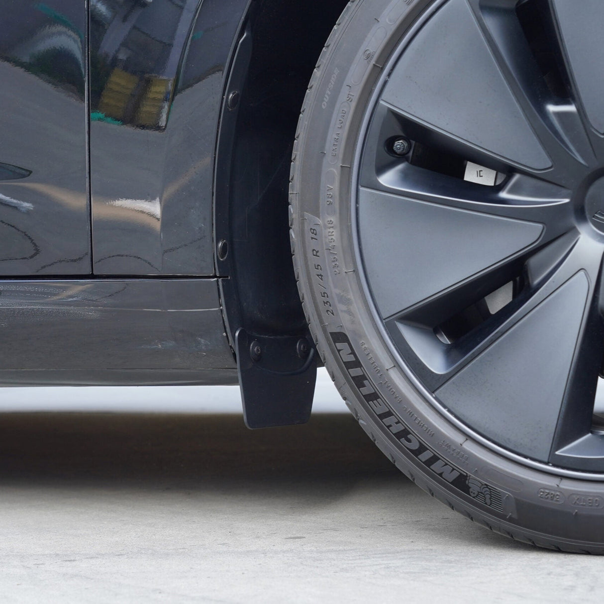 Tesla Model Y-Spritzschutz in Schwarz, montiert an den Rädern des Fahrzeugs