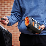 Person holder Osram TYREinflate 2110 kompressor med ledning, klar til brug ved bil