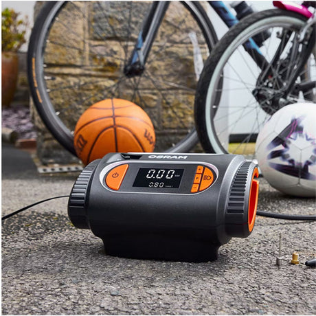 Osram TYREinflate 2120 kompressor med tilbehørsdyser, basketball, fodbold og cykel i baggrunden