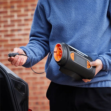 Person holder Osram TYREinflate 2120 kompressor med ledning, klar til brug ved bil