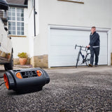 Osram TYREinflate 2130 kompressor på indkørsel med mand og cykel i baggrunden