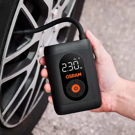 Hånd holder Osram TYREinflate 1600 og pumper bildæk, display viser 230 kPa