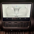 Touchscreen im Tesla Model 3/Y, der eine Abdeckung für die Belüftung zeigt, montiert auf der Mittelkonsole des Fahrzeugs.