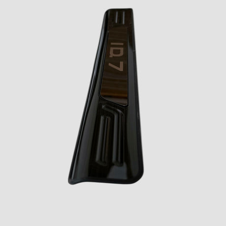 Schwarze Einstiegsleiste mit ID.7-Logo, entworfen für den Volkswagen ID.7, vor hellem Hintergrund gezeigt.