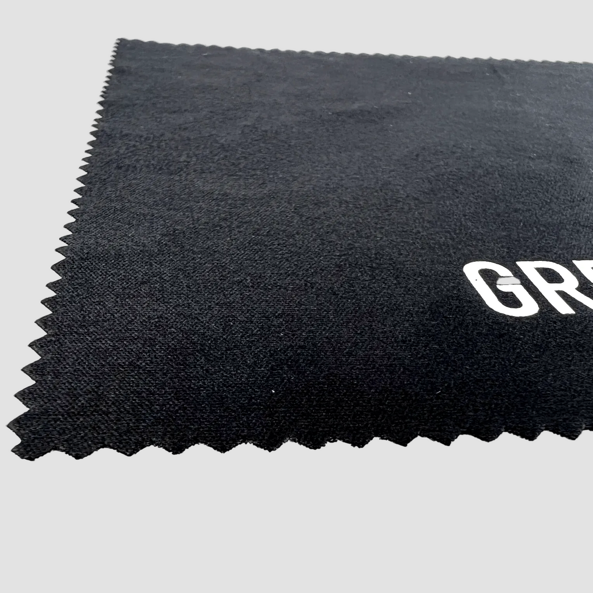 Schwarzes Mikrofasertuch mit gezackten Kanten und "GRE"-Logo.