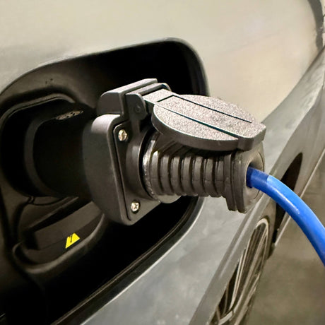 Hand, die den GCG Max V2L Adapter in den Ladeanschluss des Autos einsetzt oder entfernt