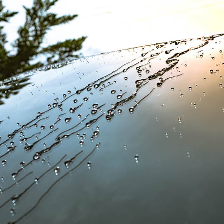 Glaco Wasserperlen auf Autoscheibe bei Regenwetter