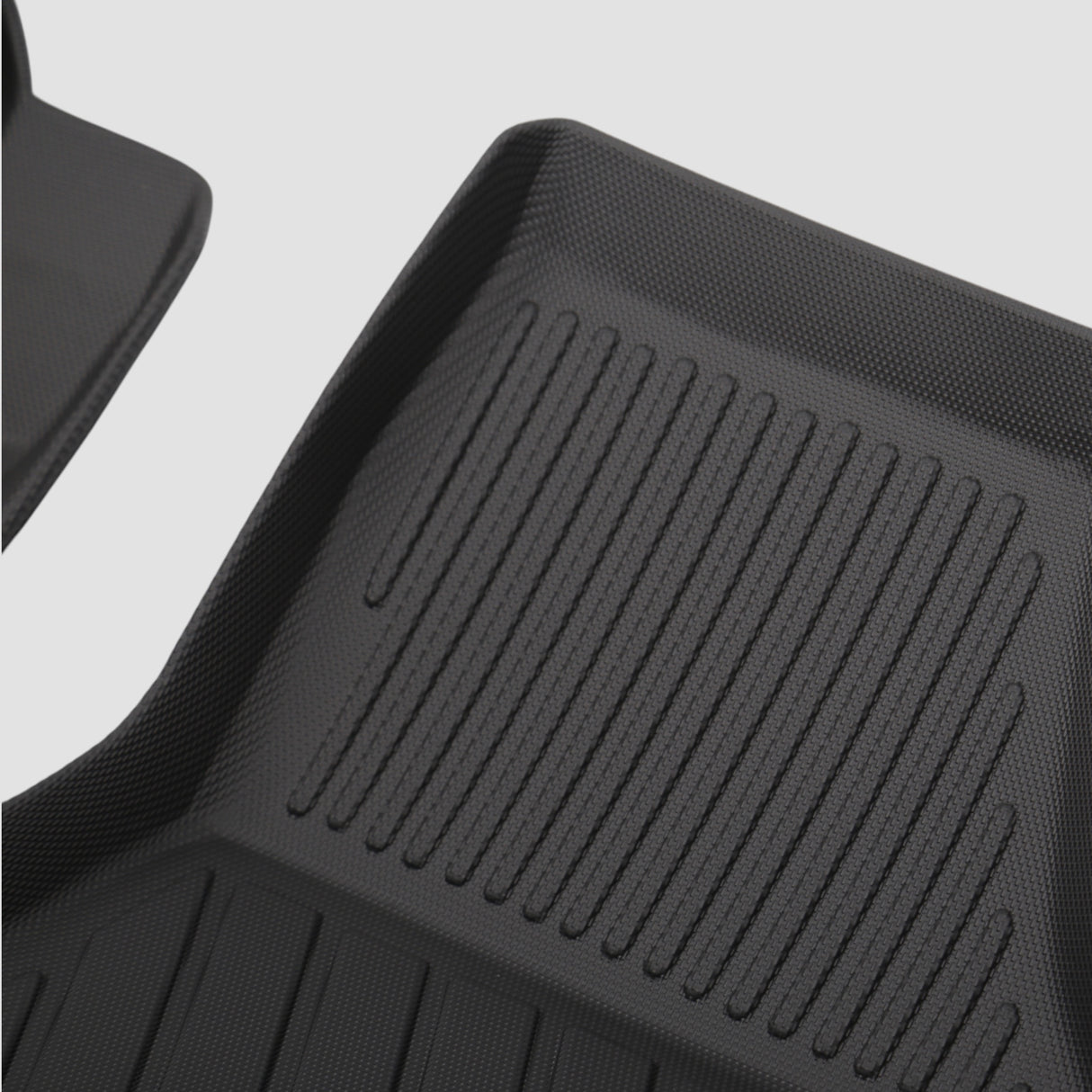 Details eines schwarzen 3D Allwetter-Fußmatten-Sets mit Rillen für den Kofferraum des Autos.