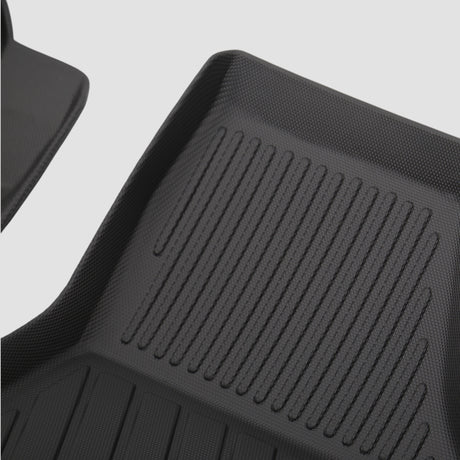 Details eines schwarzen 3D Allwetter-Fußmatten-Sets mit Rillen für den Kofferraum des Autos.