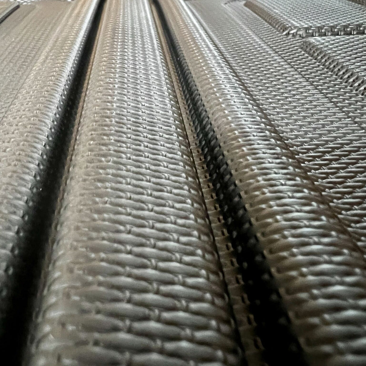 Nahaufnahme einer schwarzen Kofferraummatte mit strukturiertem rutschfestem Muster