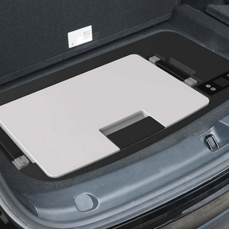 Kühlschrank im Kofferraum des Autos mit grauem Deckel montiert.