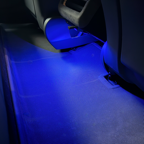Blaues LED-Licht leuchtet auf eine Matte hinter den Sitzen.