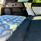 Bild einer Luftmatratzenhalterung im Auto, die zusätzlichen Platz im Kofferraum schafft.