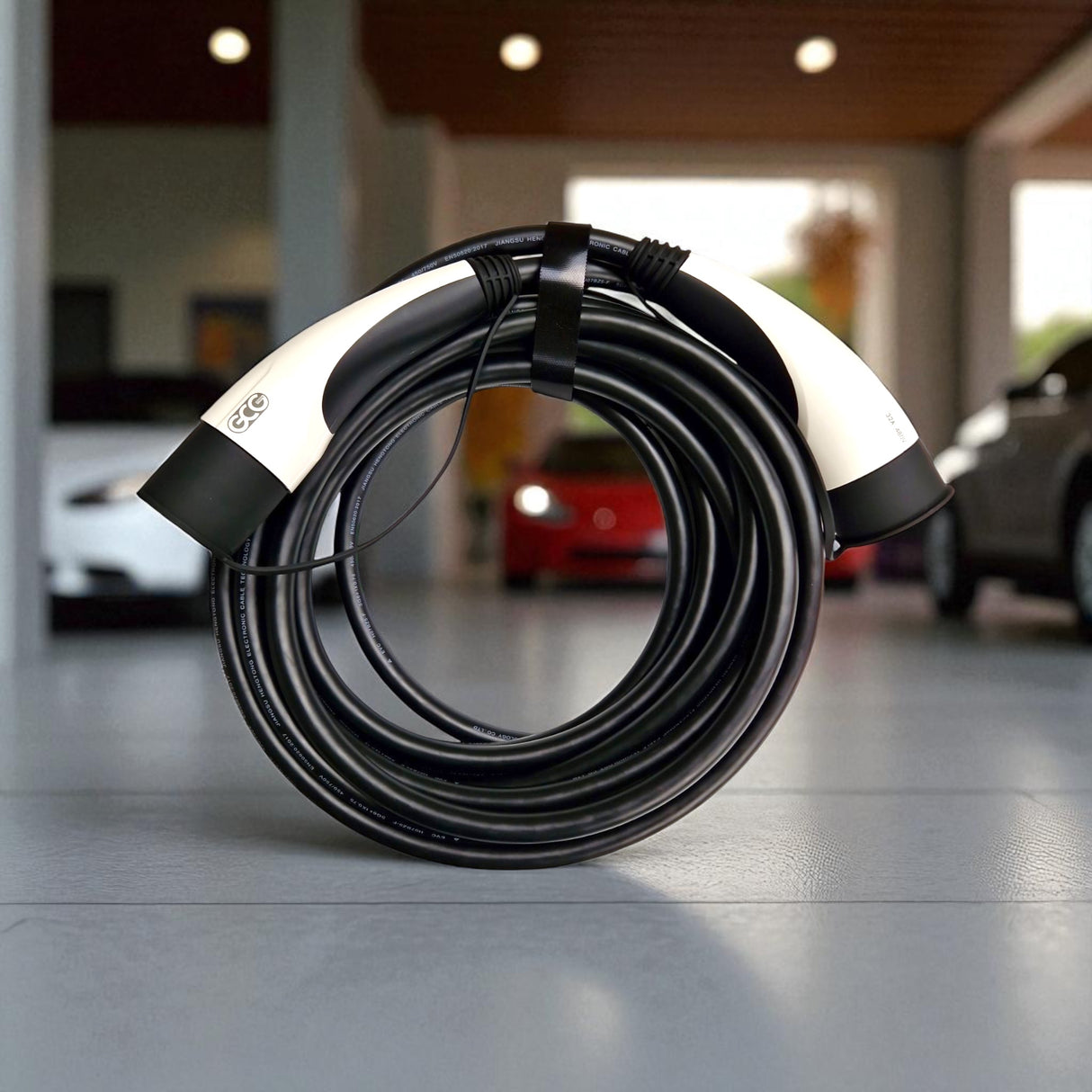 GCG MAX Ladekabel Typ 2 für Elektroautos, zusammengerollt auf Fliesenboden.