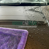 Maxshine Handtuch, das Wasser von einem Auto abtrocknet.