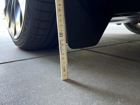 Originale Schmutzfänger am Tesla Model Y mit Lineal gemessen.