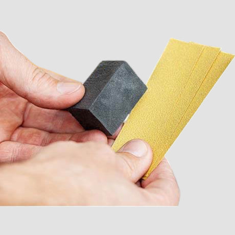 Reparaturset für Felgen mit Schleifblock und Schleifpapier zur Autopflege.