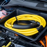 Frunk-Aufbewahrungsbox mit aufgerolltem Ladekabel im vorderen Kofferraum eines Autos.