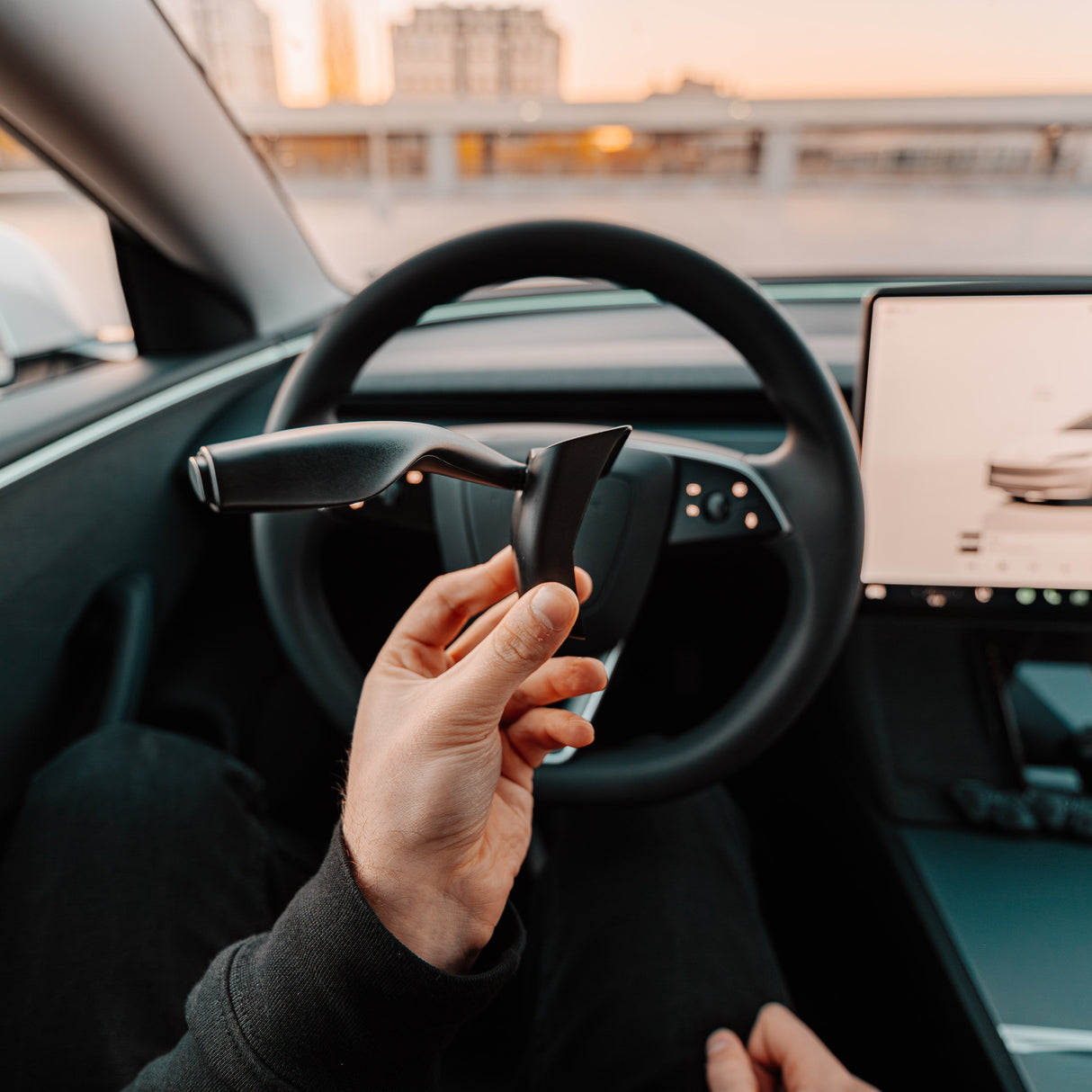 Hand hält S3XY Blinkerhebel vorne am Lenkrad des Tesla Model 3 Highland.