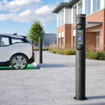 Ratio Ladestation Ladegerät weißes Elektroauto in Einfahrt vor modernem Gebäude