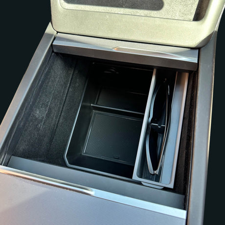 Sonnenbrillenhalter installiert in der Mittelkonsole eines Tesla mit Sonnenbrille im Halter.