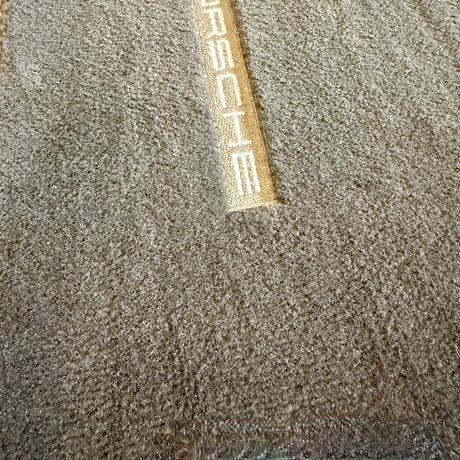 Nachher-Bild einer sauberen Auto-Fußmatte mit Porsche-Logo nach der Verwendung des Staubsaugers