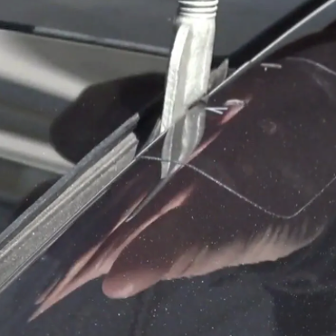 Folie schützt, während Haken für Dachträger an einem Tesla montiert werden