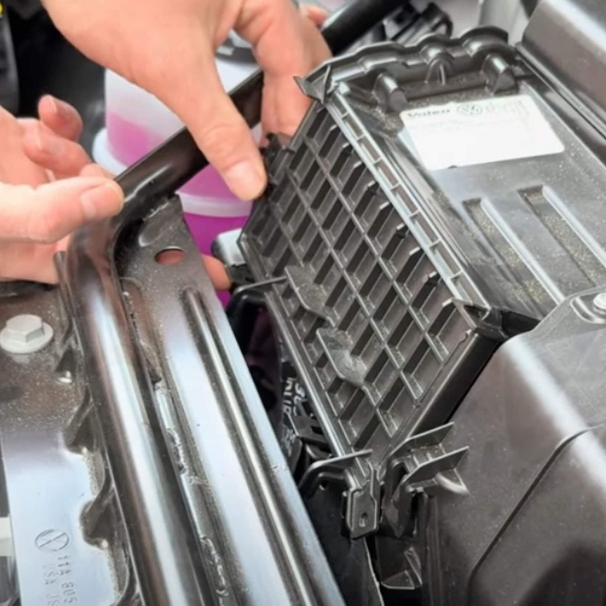 Person installiert einen Kohle-Luftfilter im Motorraum eines VW ID.3/4/5/6/7.